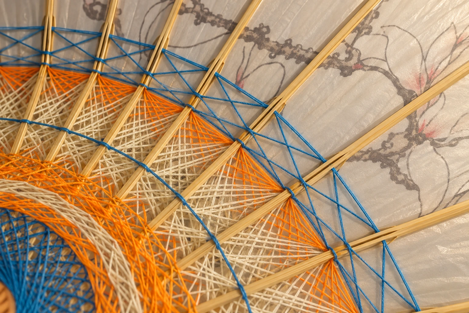 Blue, orange and ivory lacing across bamboo ribs, illustrated from the supplied umbrella detail.